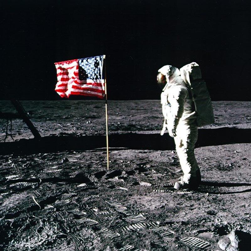 Astronaut on the moon next to the US flag