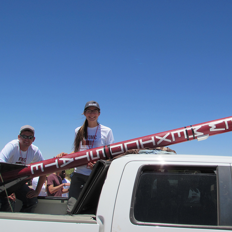 Students standing in front of competition rocket